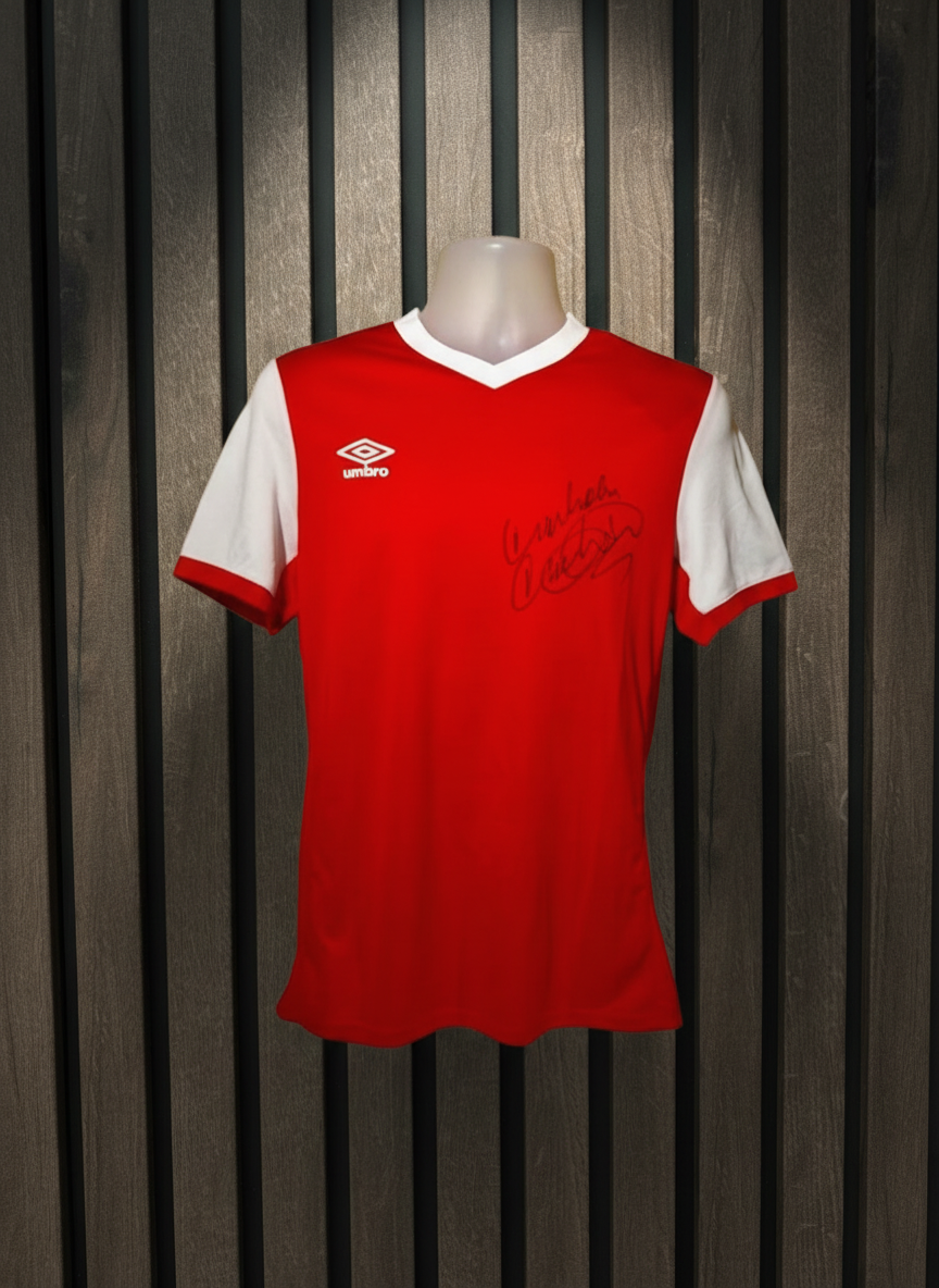 Signed red football shirt on wooden background